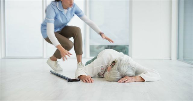 転倒した高齢者に駆け寄る介護職